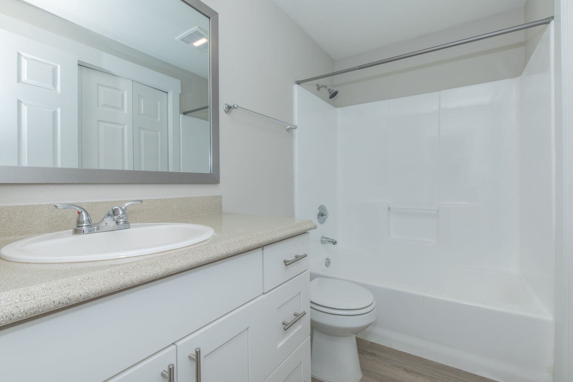 A bathroom with a sink , toilet , bathtub and mirror.