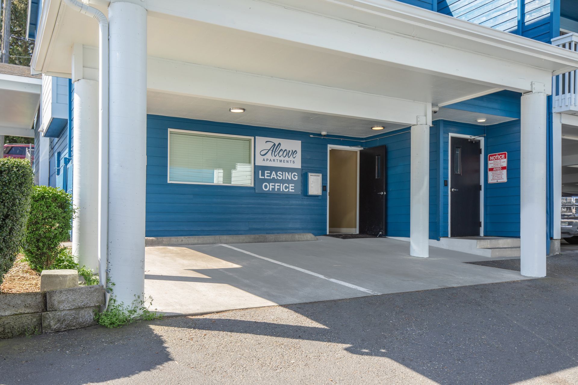 A blue building with a parking lot in front of it.