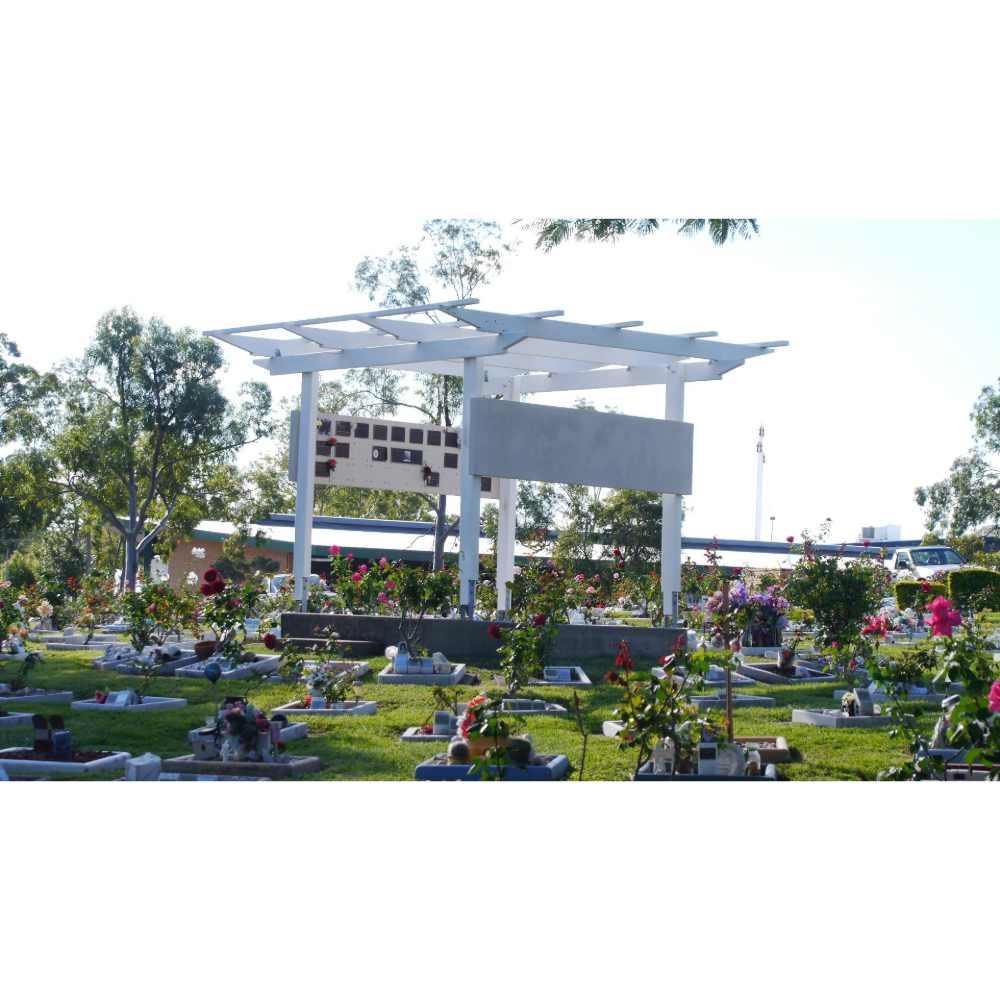 Cemetery with white pergola in the center, surrounded by headstones and rose bushes. Sunny day.— Rockhampton Crematorium in Norman Gardens, QLD
