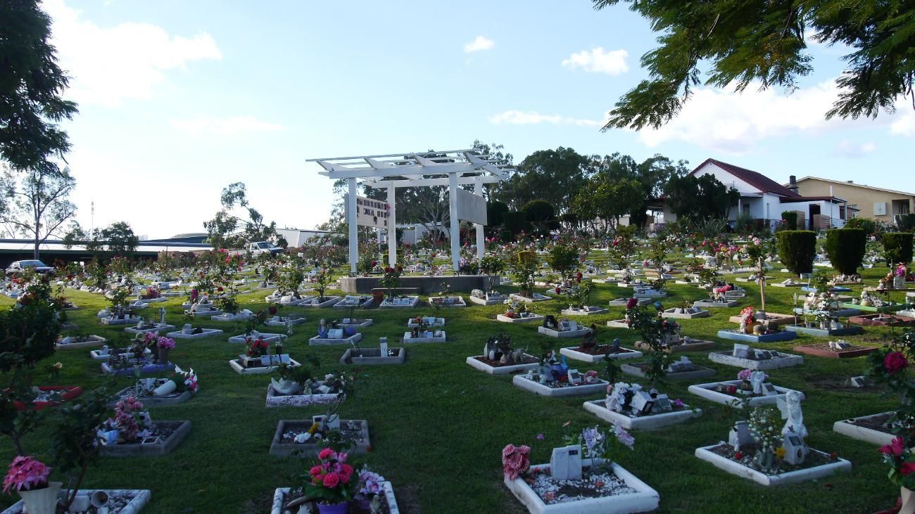 Cemetery with Numerous Headstones on A Grassy Lawn, a White Pergola in The Center — Rockhampton Crematorium in Norman Gardens, QLD
