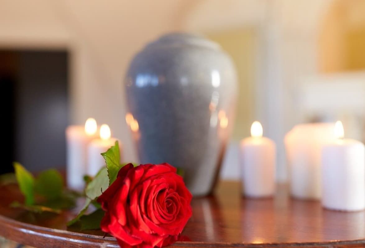A Red Rose Is Sitting On A Table Next To Candles — Rockhampton Crematorium in Norman Gardens, QLD