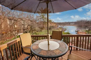 Wooden deck with construction materials against a beige fence and trees, daytime.