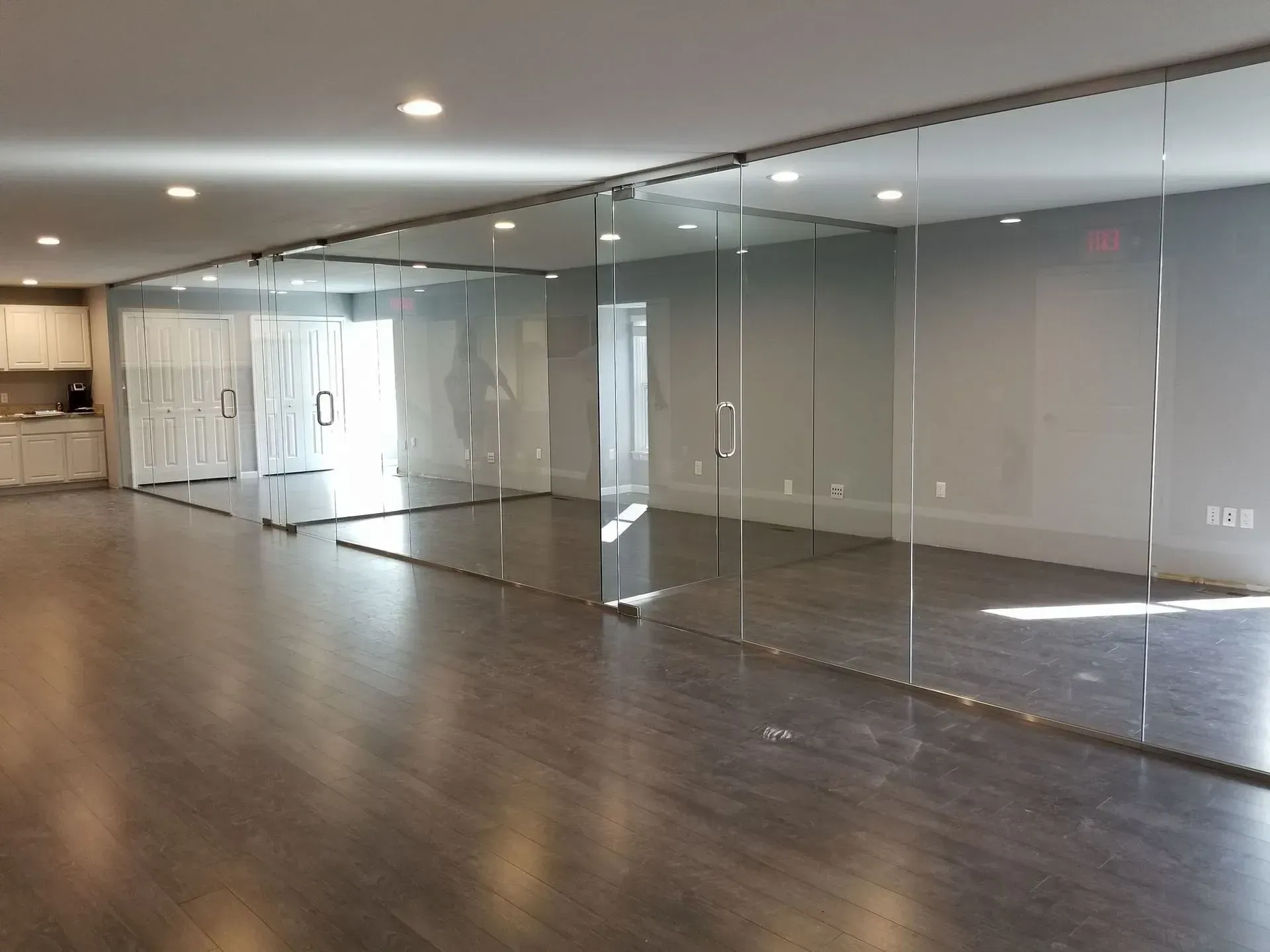 A large empty room with a lot of glass walls and doors.