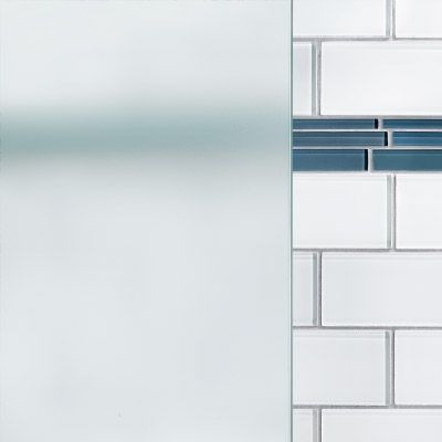 A close up of a white brick wall with a blue tile border and a glass panel over top.