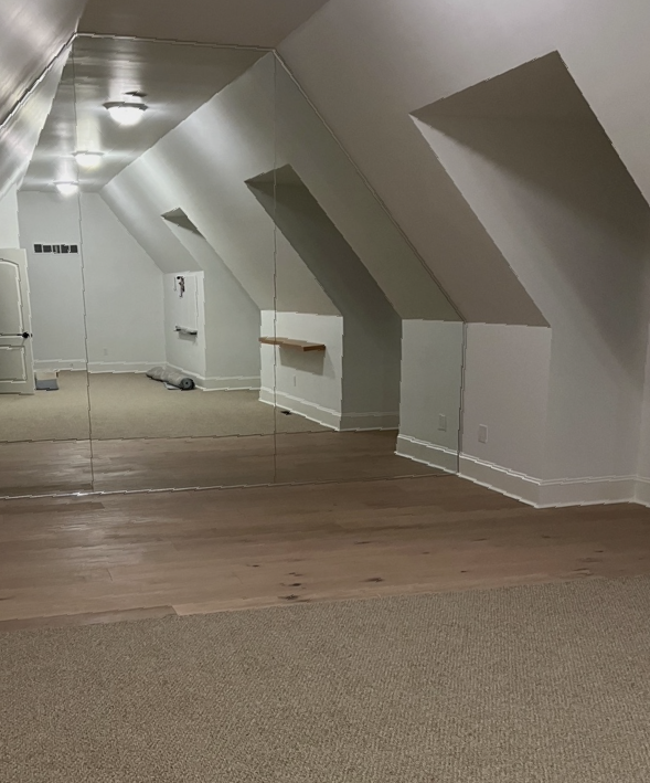 An empty room with a large mirrored wall.