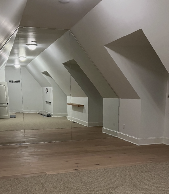 An empty room with a large mirror on the wall