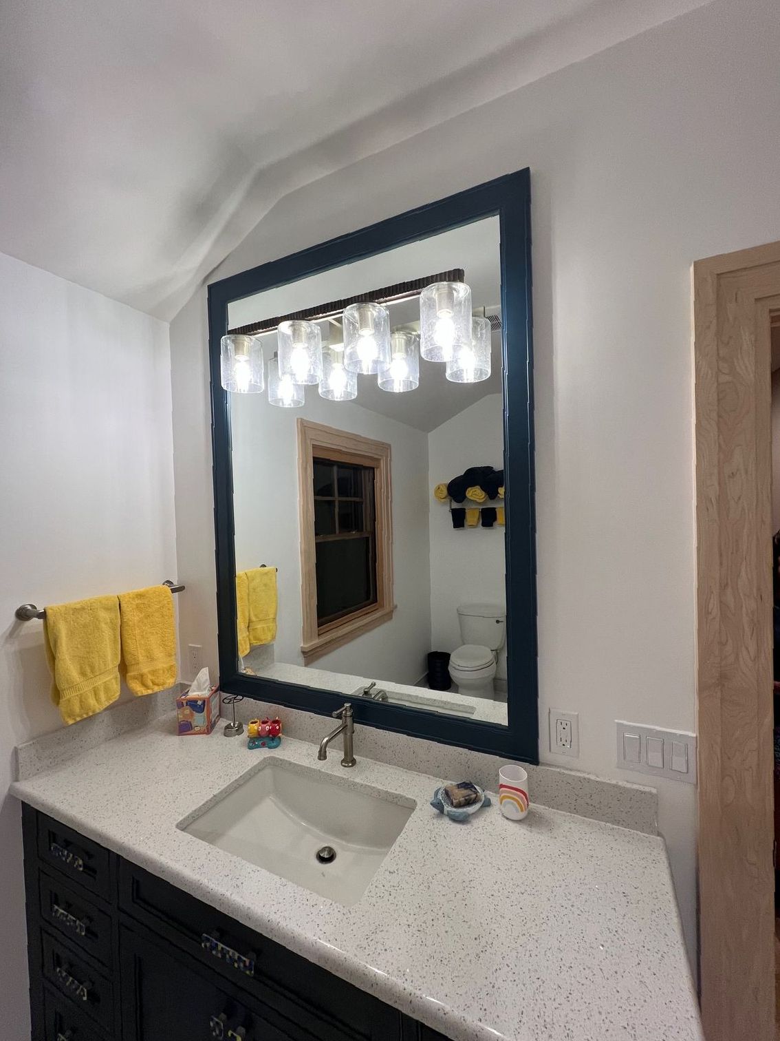 A bathroom with a sink and a large mirror.