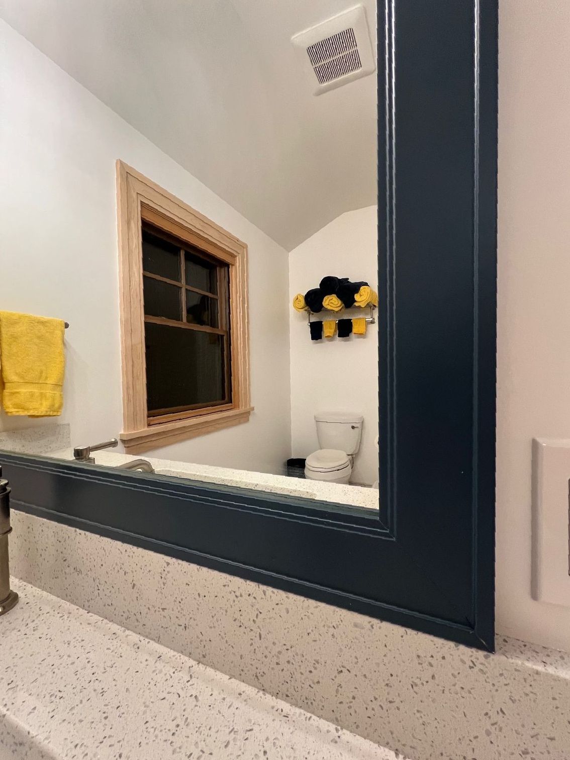 A bathroom with a large mirror and a sink.