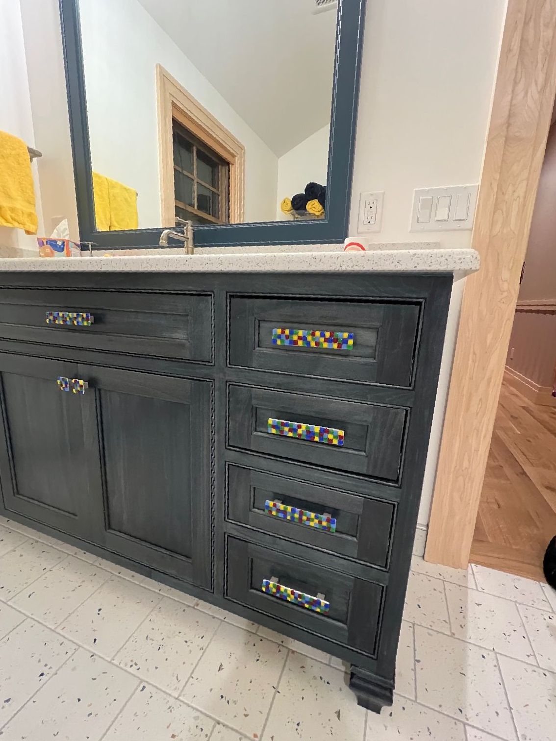 A bathroom vanity with drawers and a mirror.