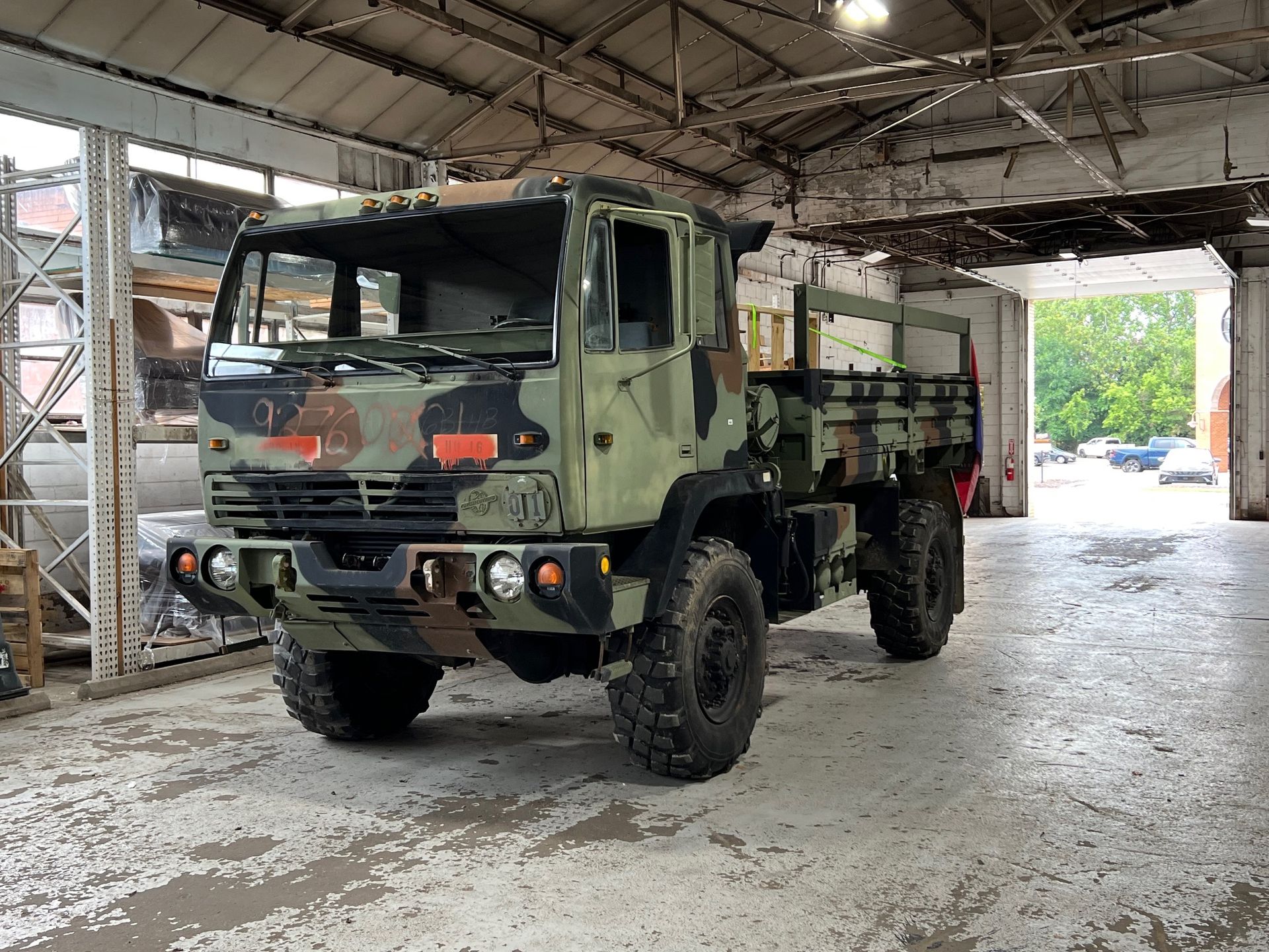 Camouflaged military truck inside a garage.