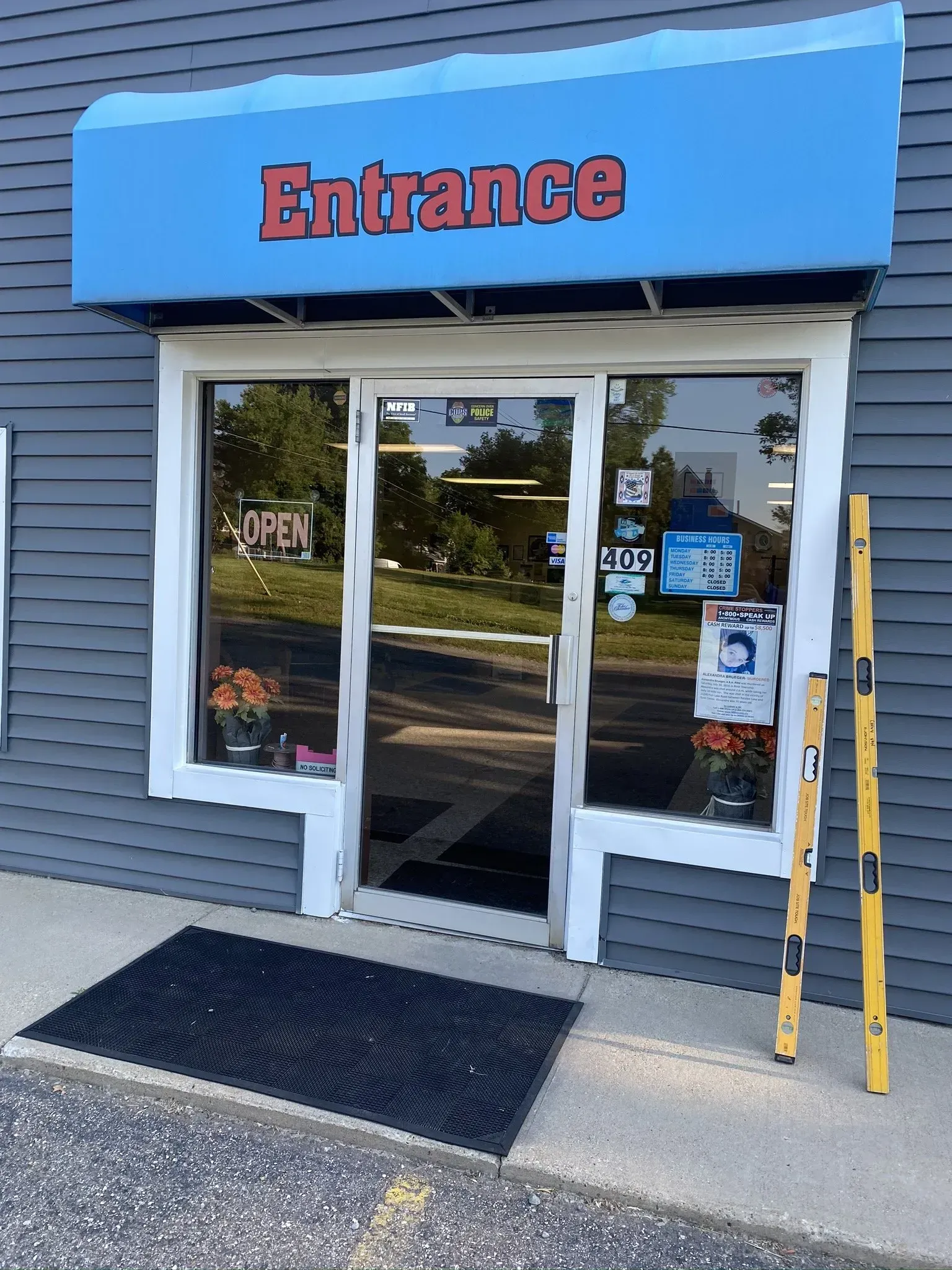A store front with a glass doorway that says entrance.