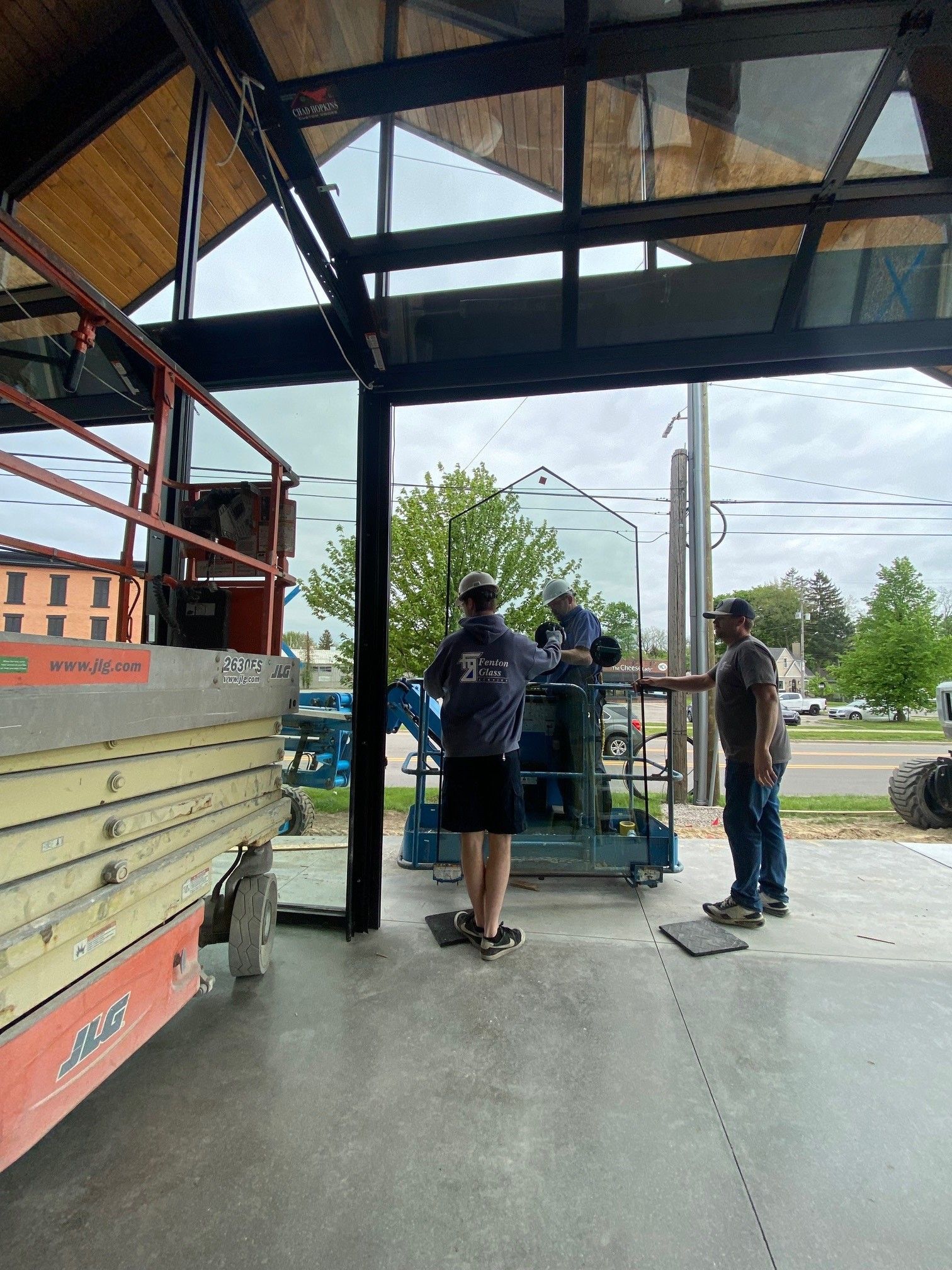 A group of men are working on a large piece of glass in a building.