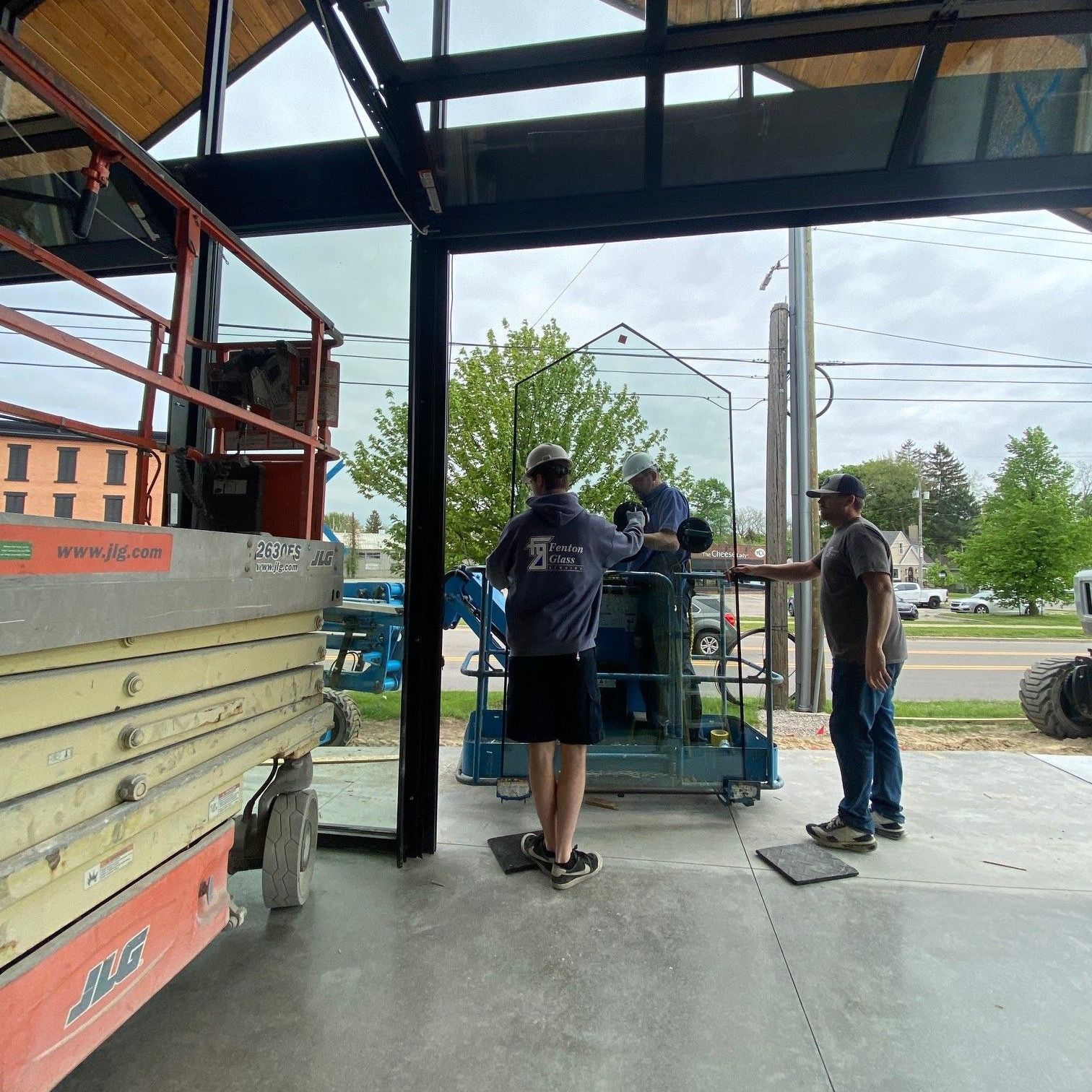 A group of men are working on a large glass window.