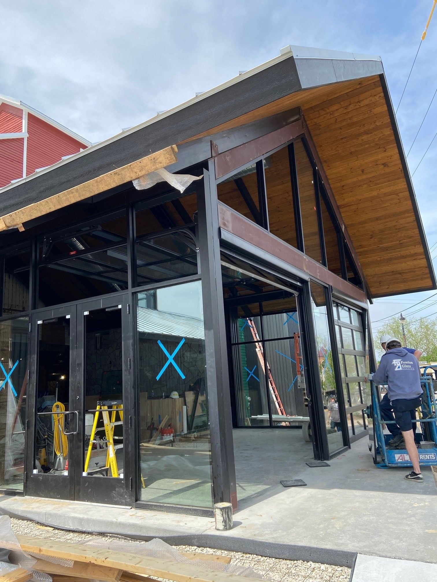 A large building with a lot of windows and a wooden roof is being built.