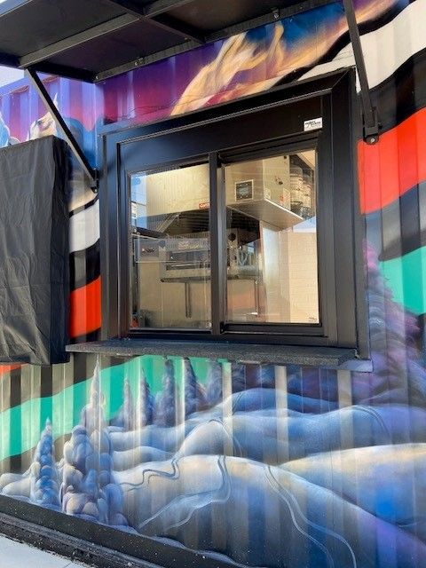 A colorful building with a window and a painting on the wall.