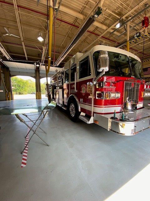 Fire engine parked inside a garage, red and white, ready for service.