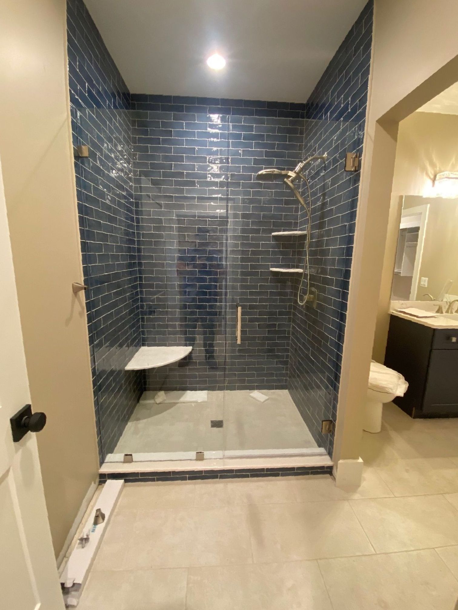 A bathroom with a walk in shower and a toilet.