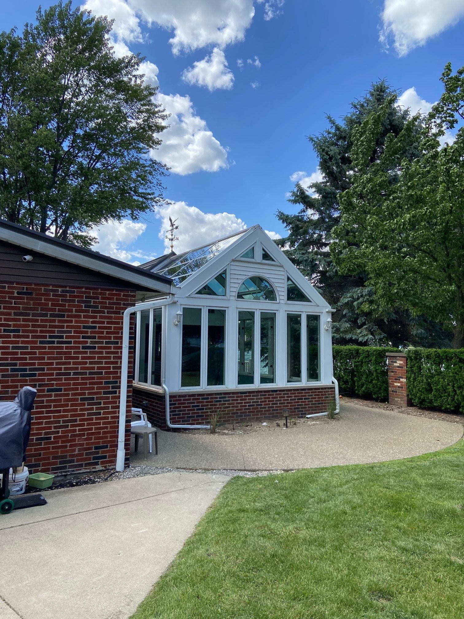A brick house with a greenhouse on the side of it.