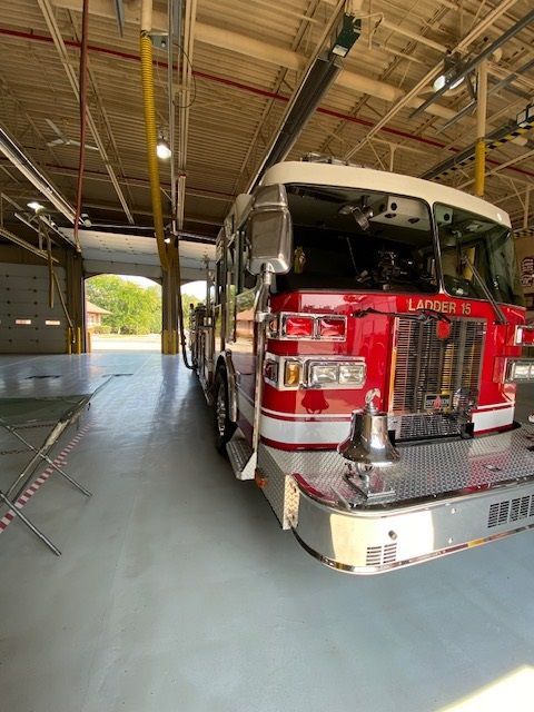 A red fire truck parked inside a garage; it's facing forward.
