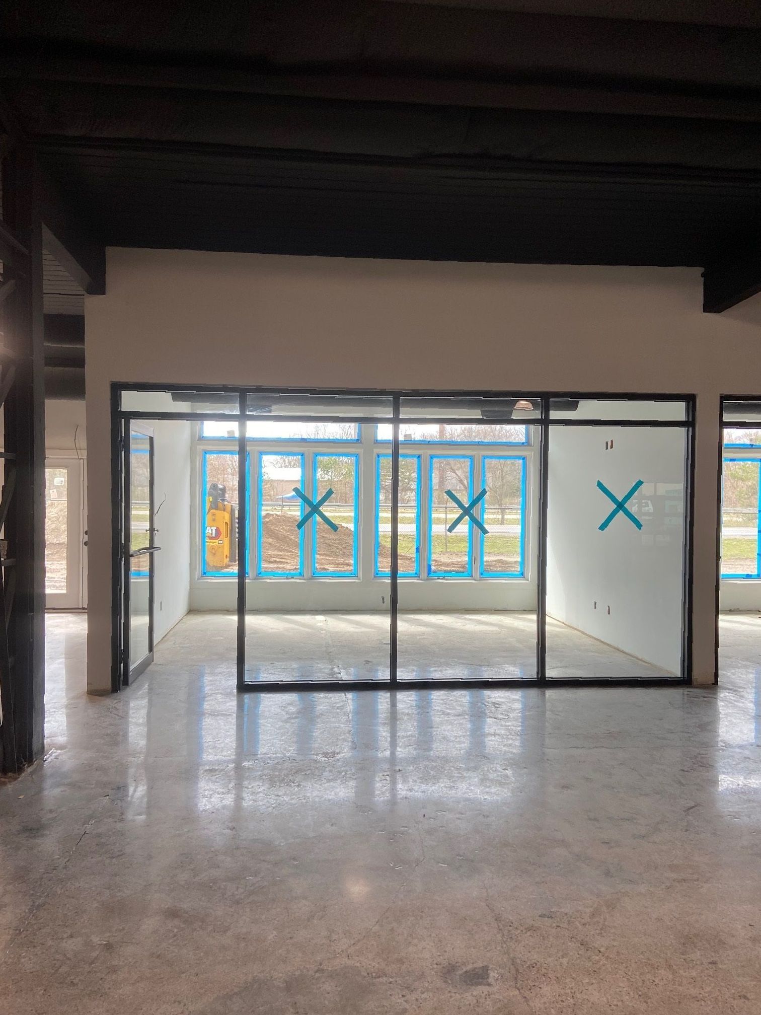 A large empty room with a lot of windows and sliding glass doors.