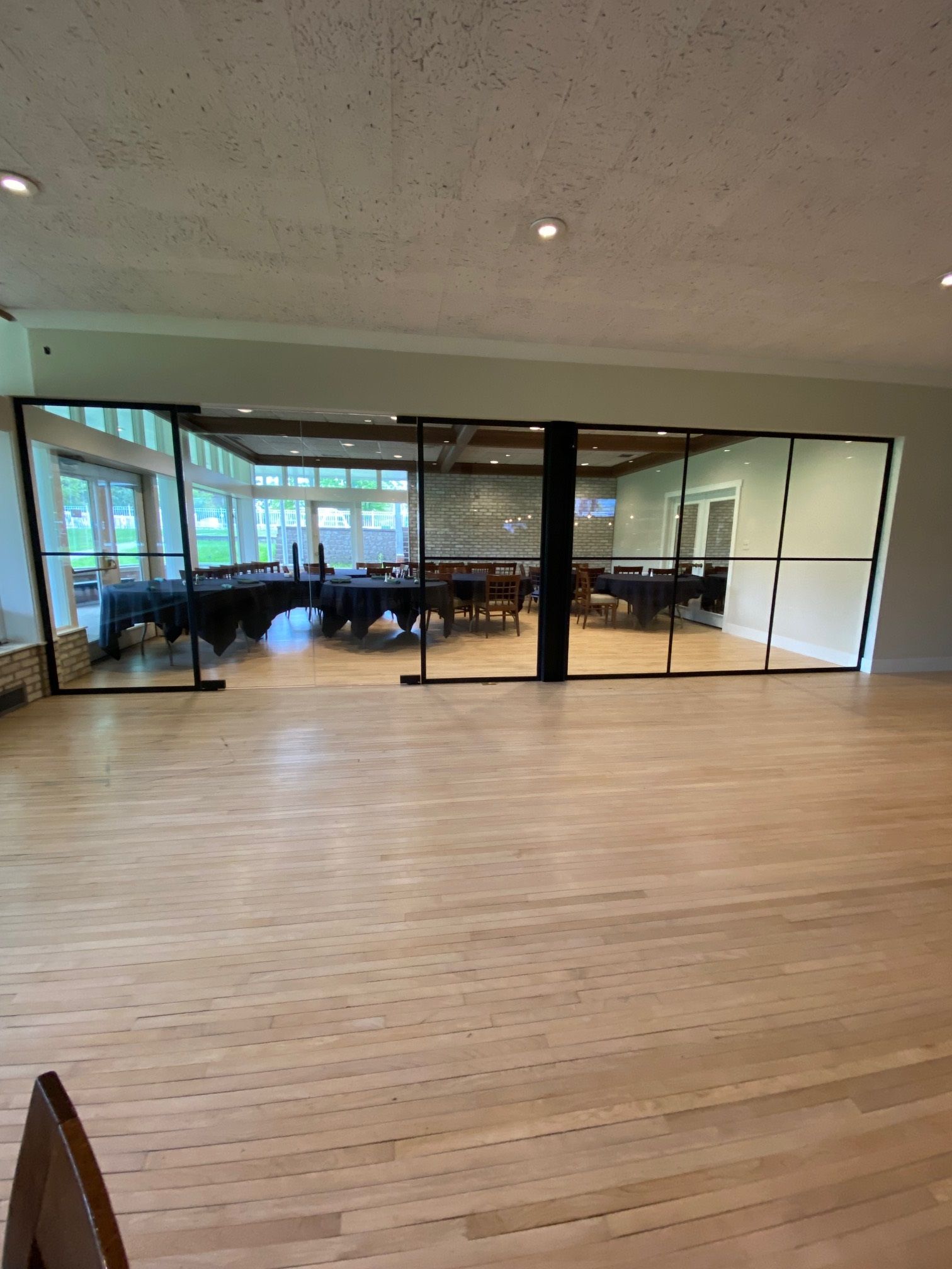 A large room with wooden floors and sliding glass doors and glass walls.