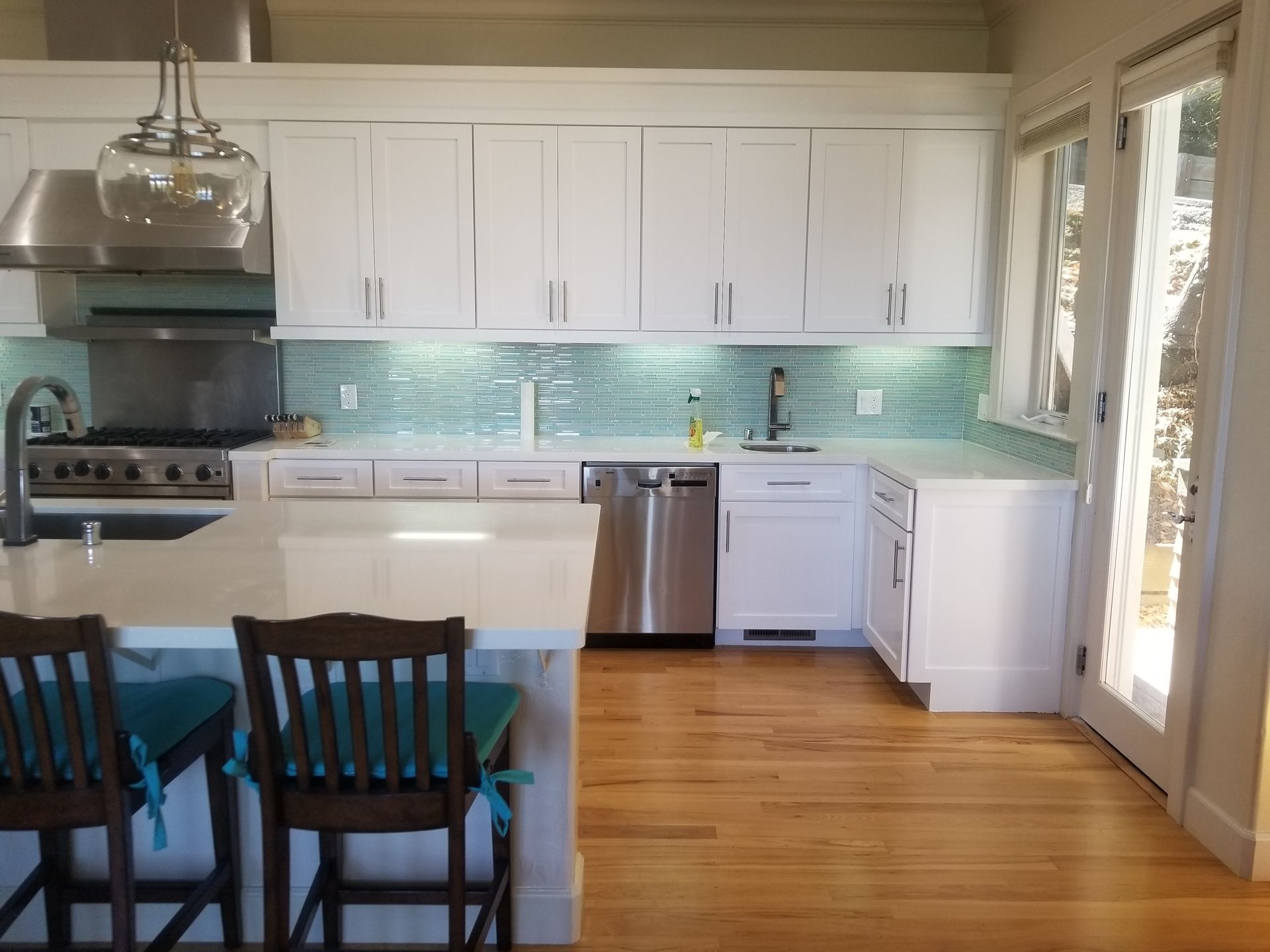 A kitchen with wooden cabinets , stainless steel appliances , a sink , and a large island.
