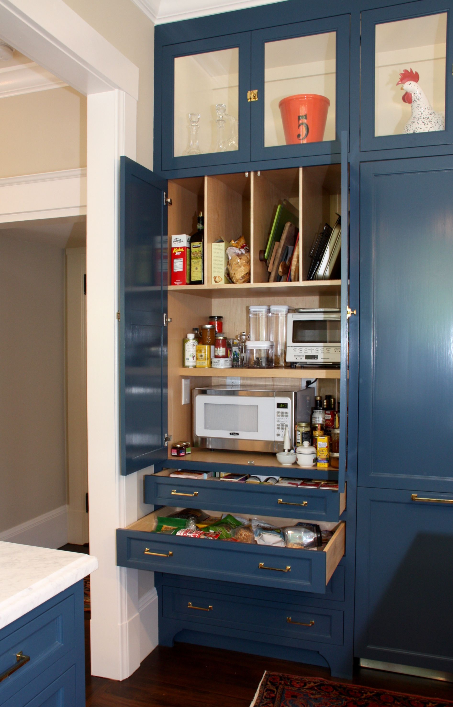 A kitchen with white cabinets and black cabinets and a large island in the middle.