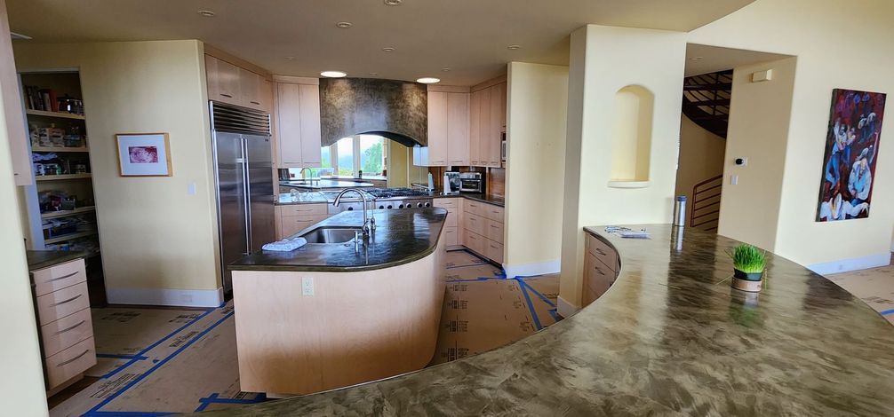 A kitchen with wooden cabinets , granite counter tops , stainless steel appliances and a large island.