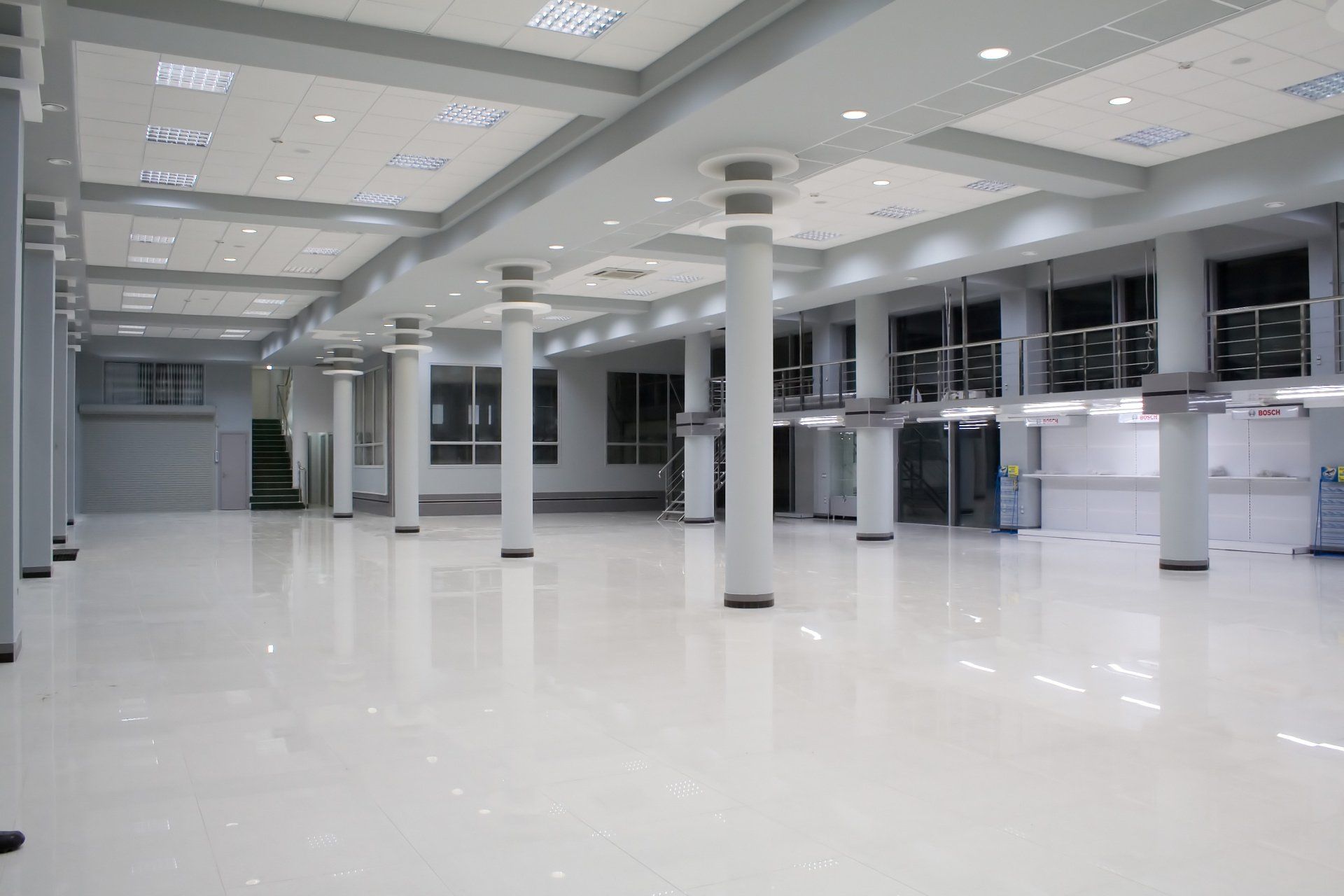 A large empty room with columns and a lot of windows.