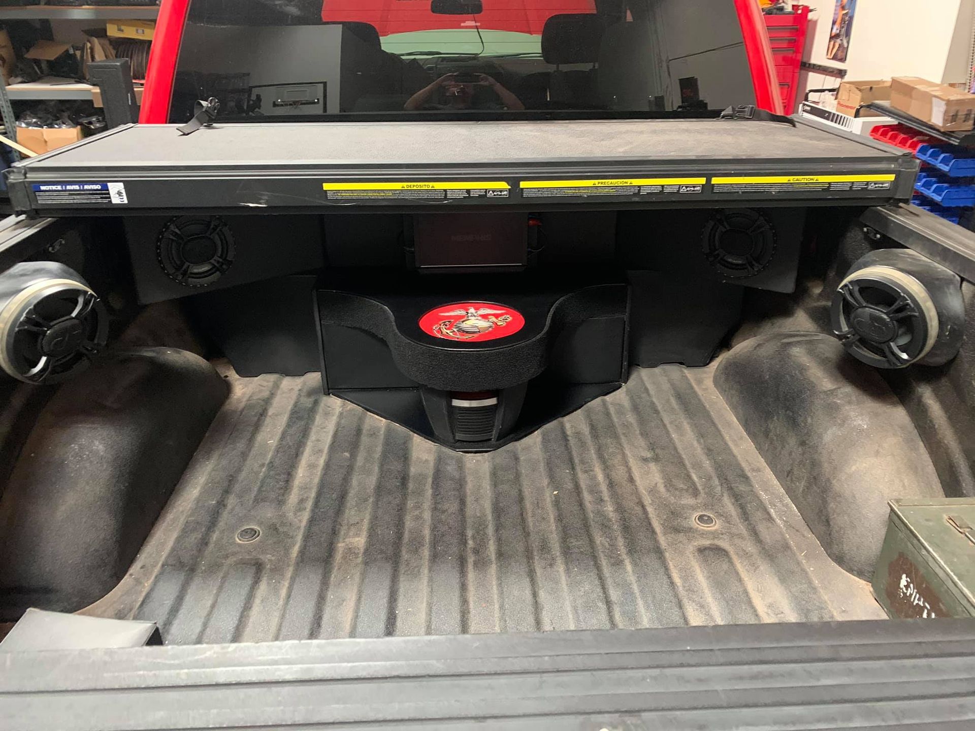 Truck bed with audio system installed, including two speakers and a subwoofer.