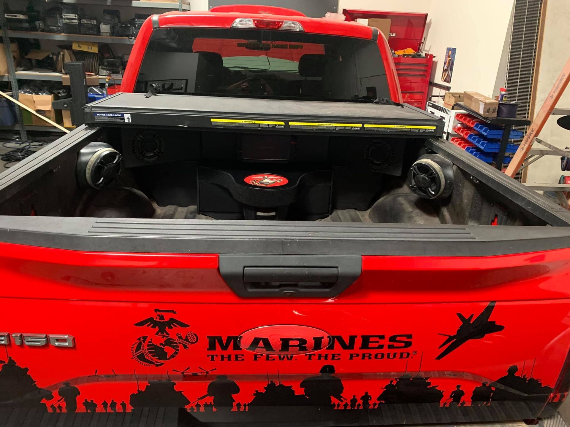 Red pickup truck bed with a custom sound system. A 