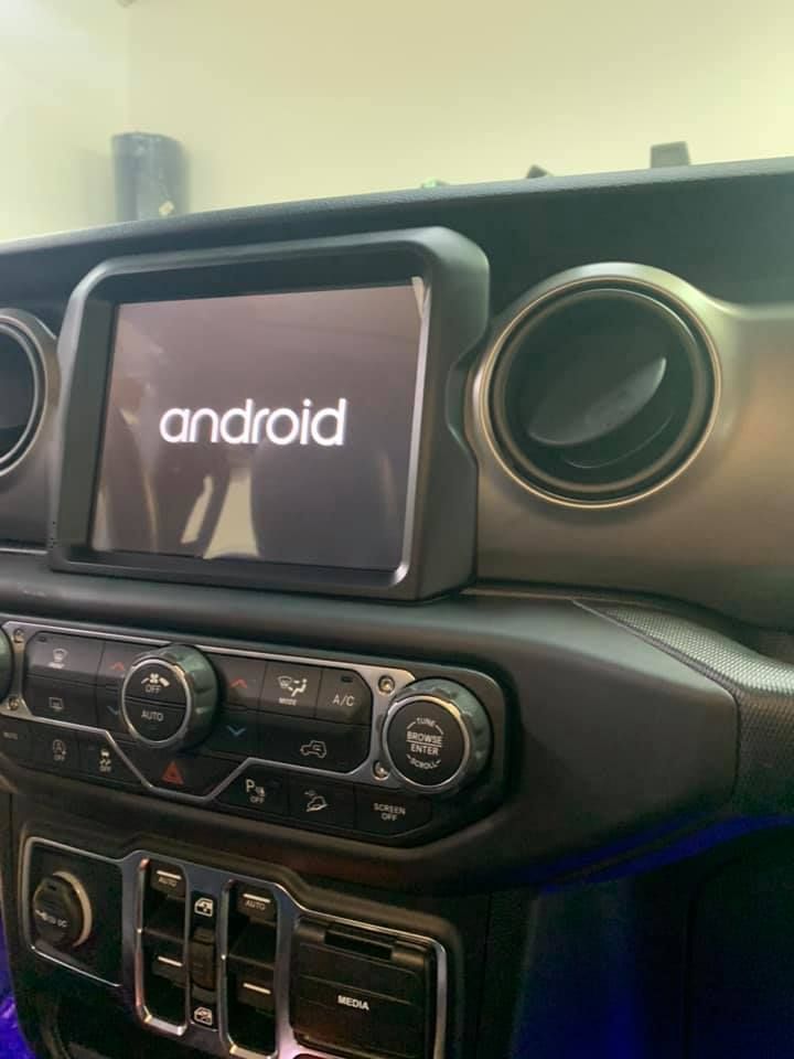 Android-powered car dashboard with a touchscreen display, climate controls, and air vents.