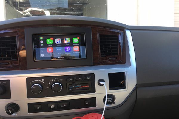 Interior of a vehicle showing a touchscreen display with Apple CarPlay interface installed in the dashboard.