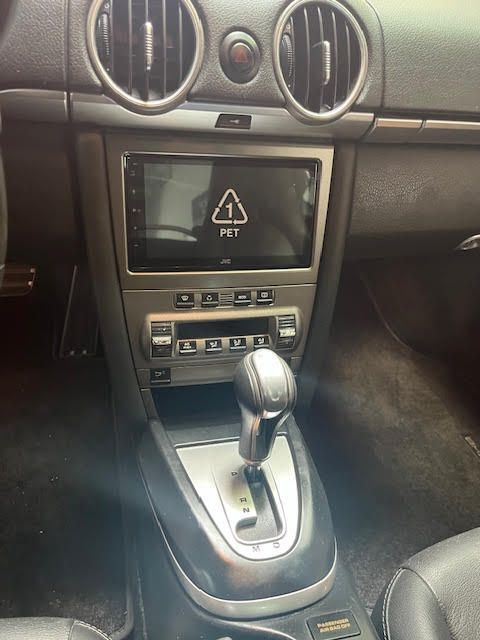 Car interior with a center console, automatic gear shift, and aftermarket radio.