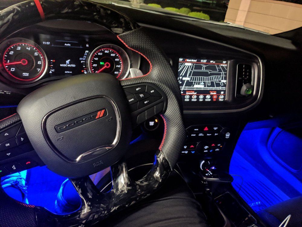 Interior view of a Dodge Charger, with a steering wheel, dashboard, and infotainment screen visible.