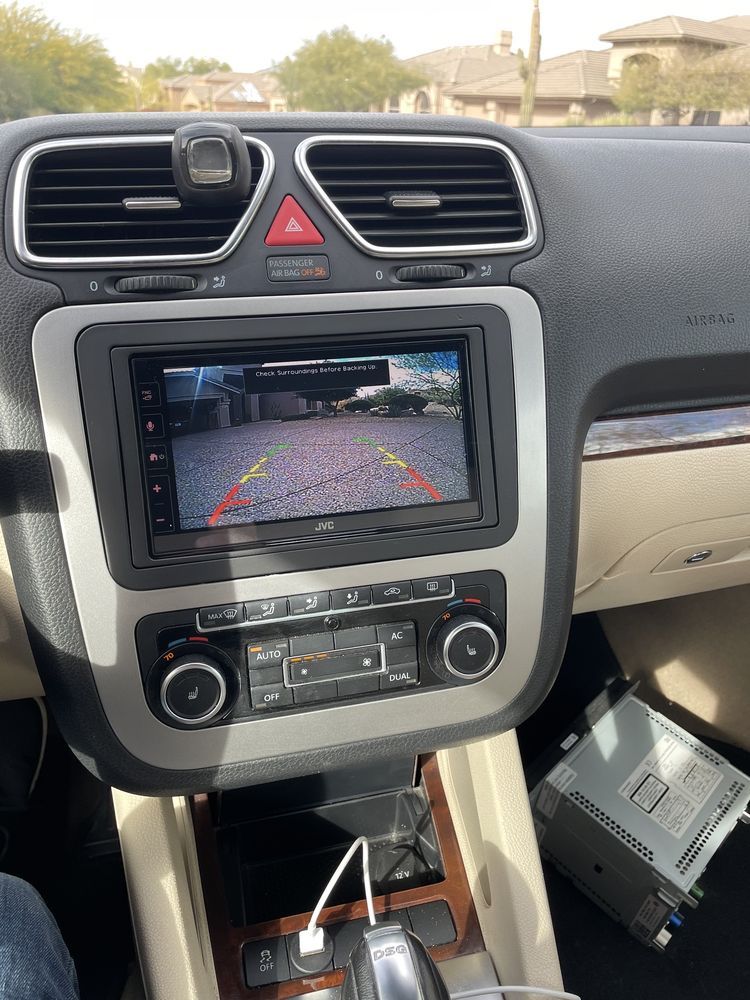 Car's dashboard displaying a rear-view camera on a touchscreen.  A new stereo head unit sits in the dashboard.