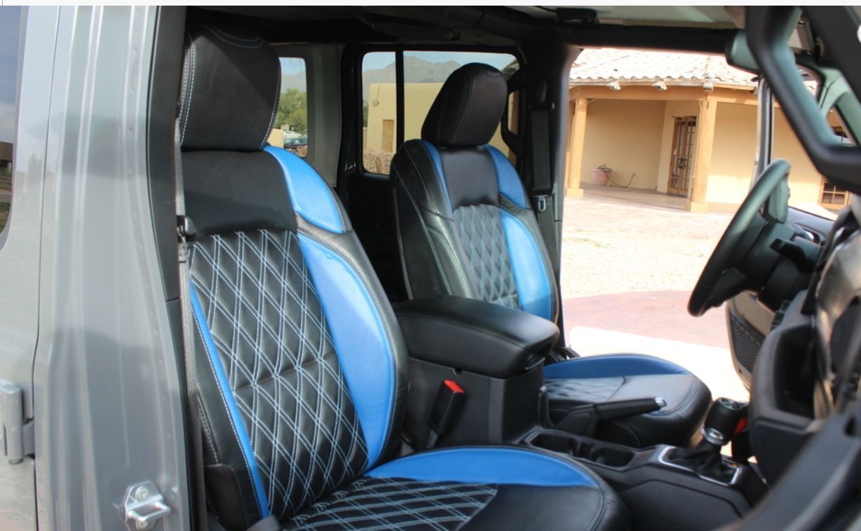 Interior view of a Jeep with black and blue leather seats. 