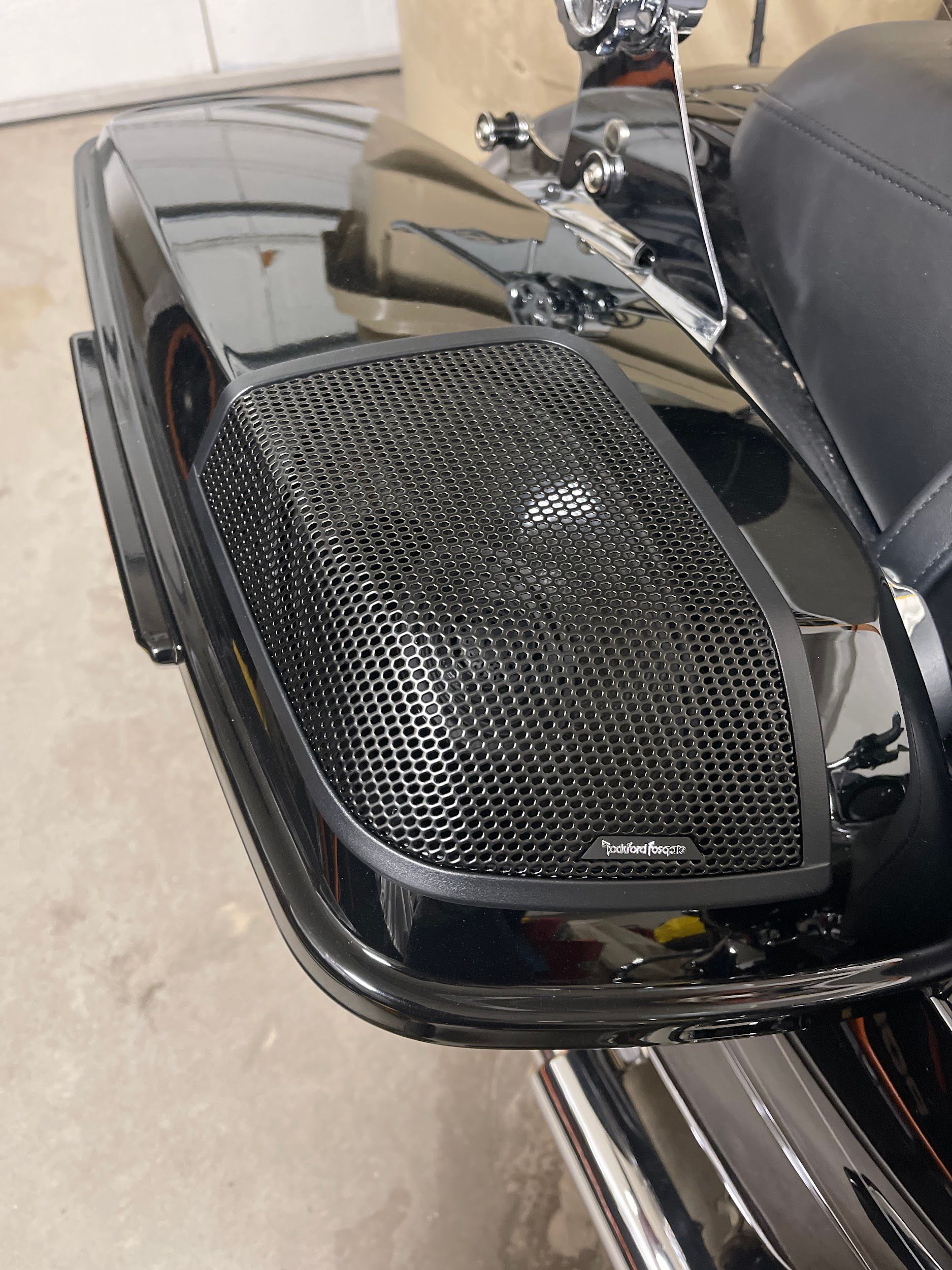 Black motorcycle saddlebag with a mesh speaker grille, likely for audio.