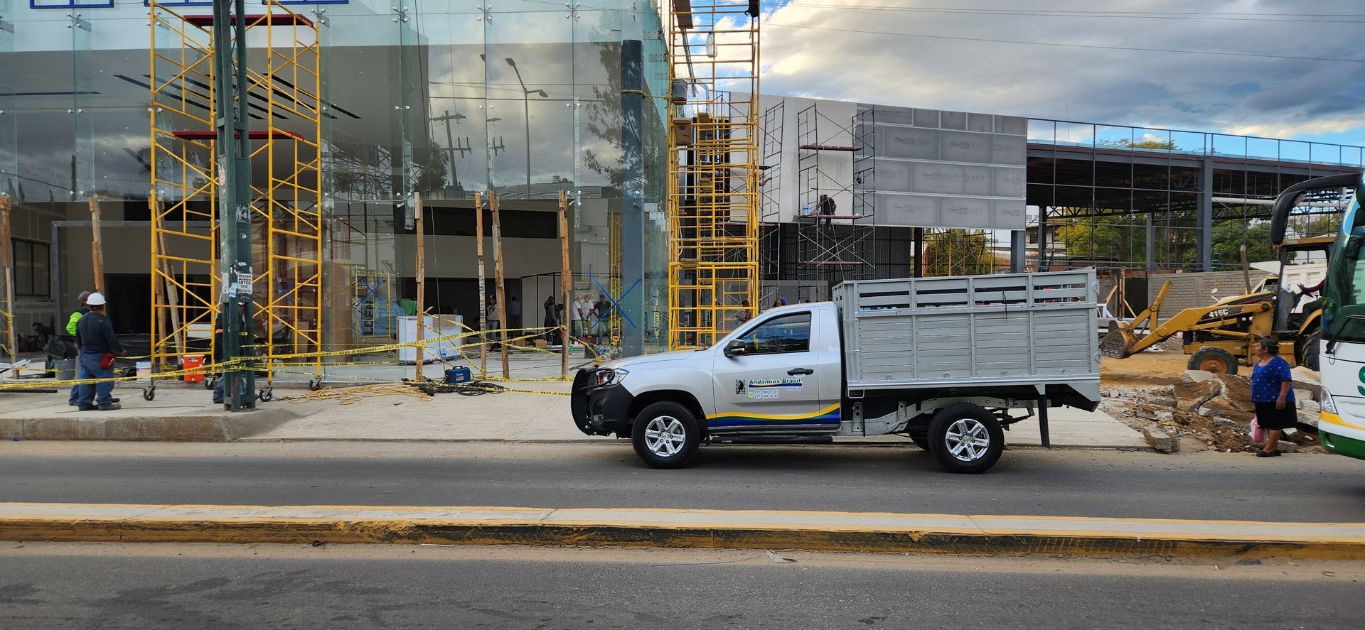 Una camioneta blanca estacionada frente a un edificio en construcción.