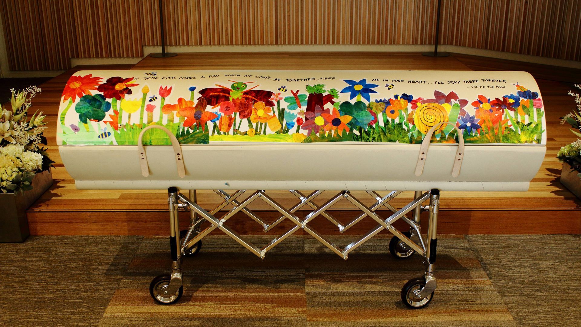 A coffin with a painting of flowers on it