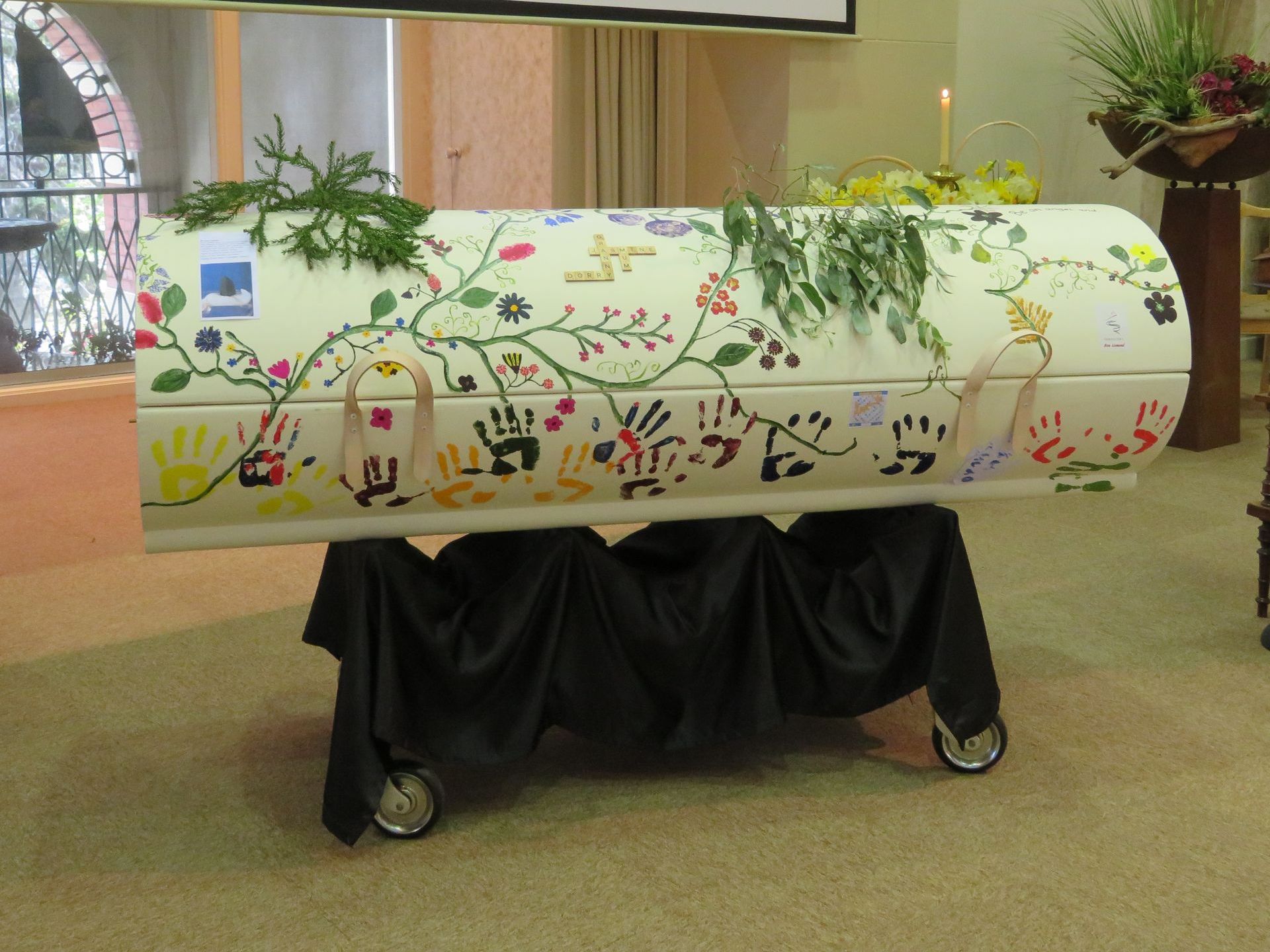A white coffin with flowers painted on it