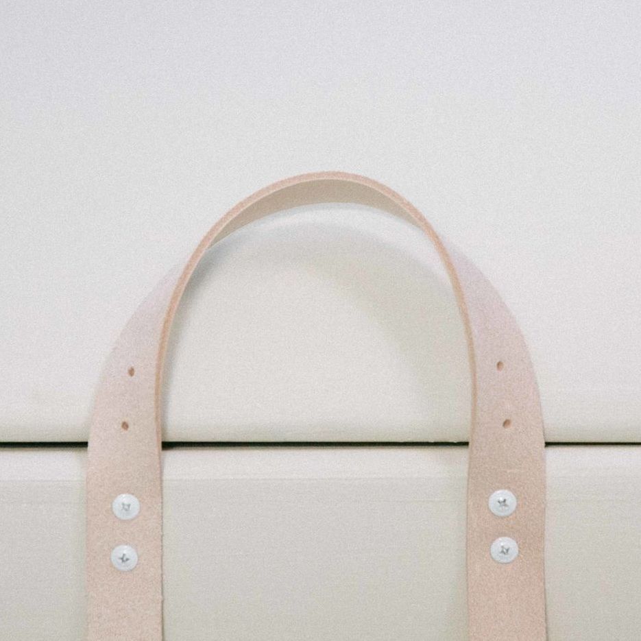 A close up of the leather handle of a PeacePod casket with buttons on it