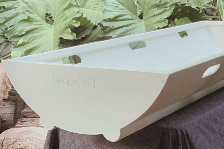 A white shroud bearer tray is sitting on top of a wooden table.