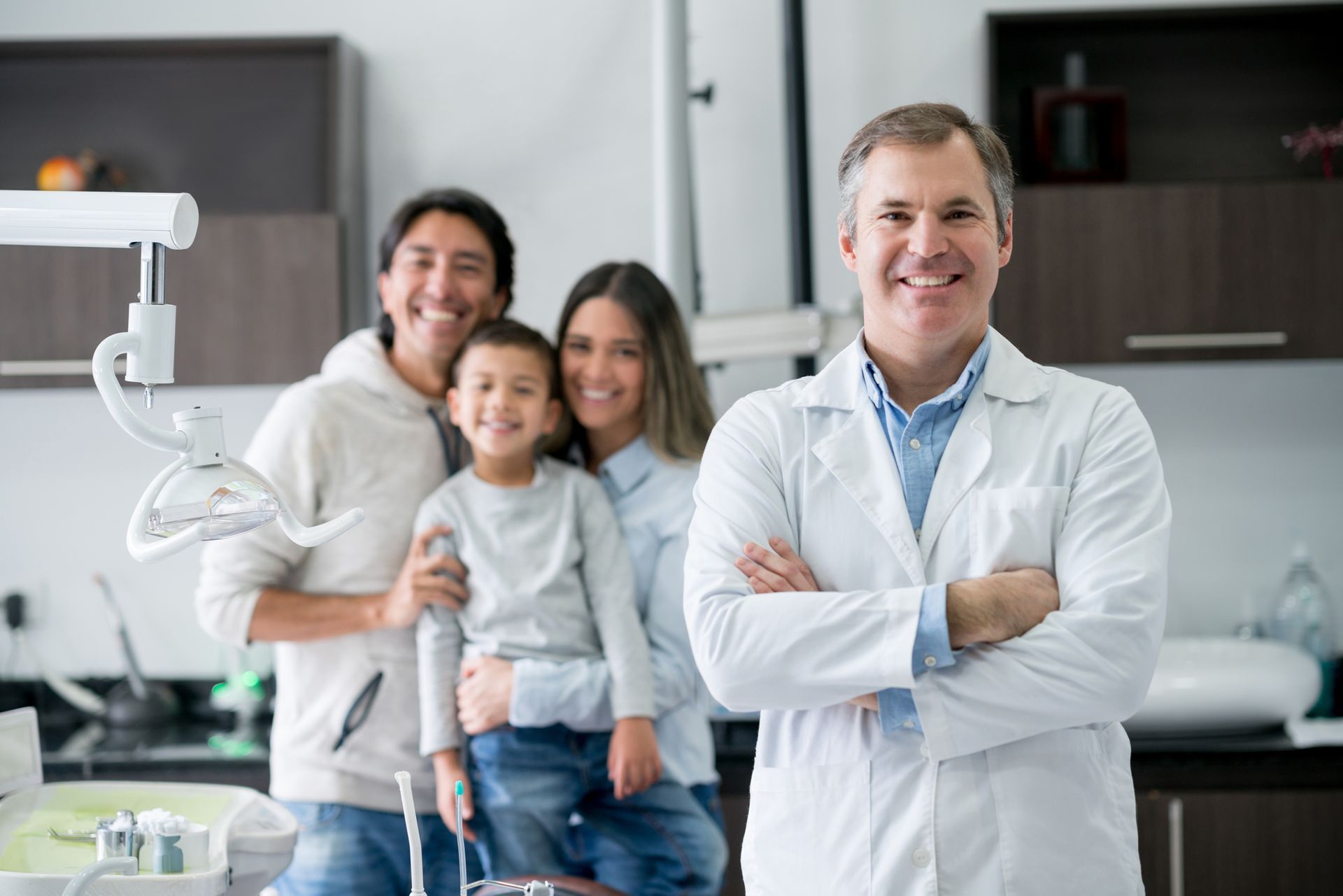 Smiling dentist with happy family in dental office providing trusted family dental services.