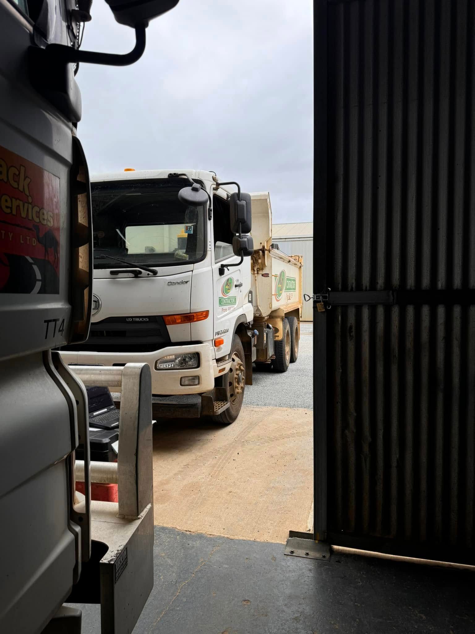 White truck inside a doorway, viewed from side.