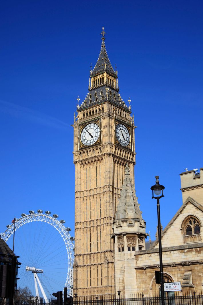 Big ben clock tower in london with a ferris wheel in the background