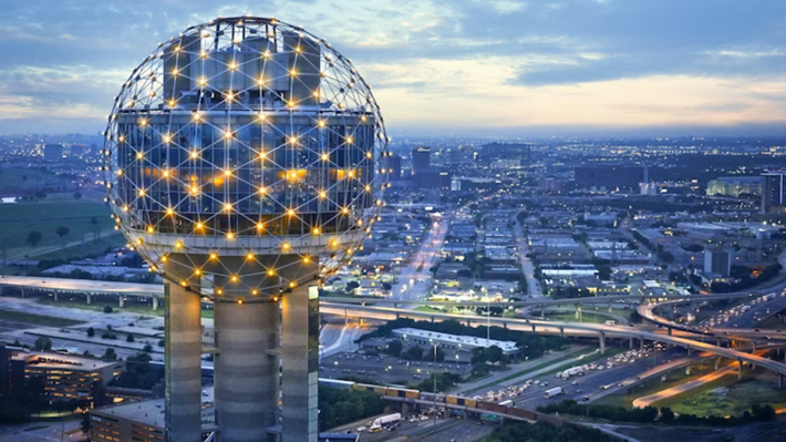 An aerial view of a city at night with a water tower in the foreground.