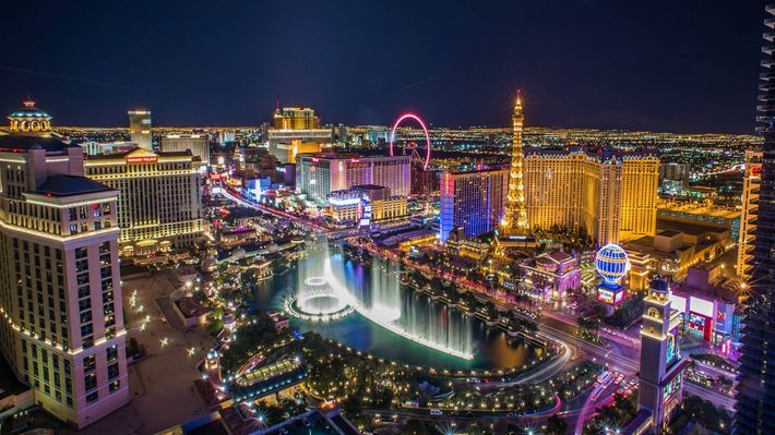 An aerial view of las vegas at night with a waterfall in the middle of the city.