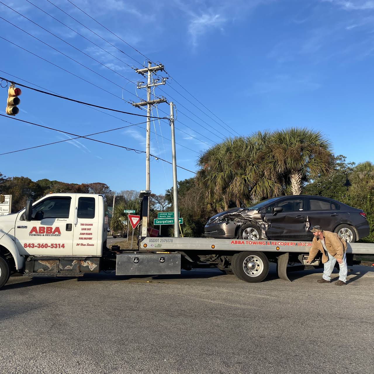 A tow truck with a car on the back of it