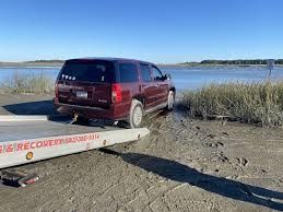 A red suv is being towed by a tow truck.